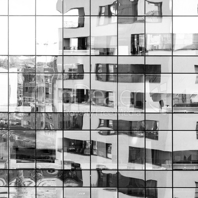 Modern black and white building reflected on glass facade