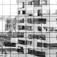 Modern black and white building reflected on glass facade