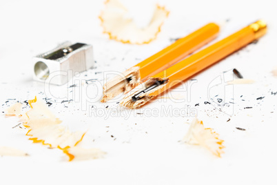 Broken pencil with metal sharpener and shavings.