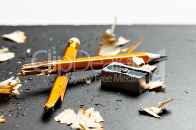 Broken pencil with metal sharpener and shavings.