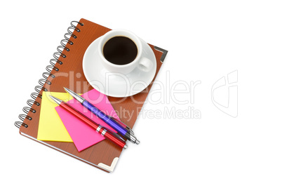 Notebook and cup of coffee isolated on white background. Free sp