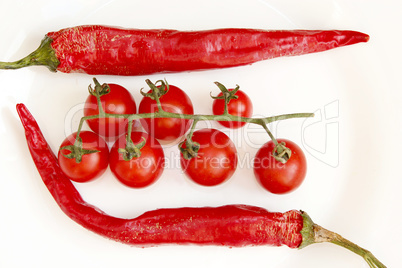 tomatoes and pods of chili peppers isolated