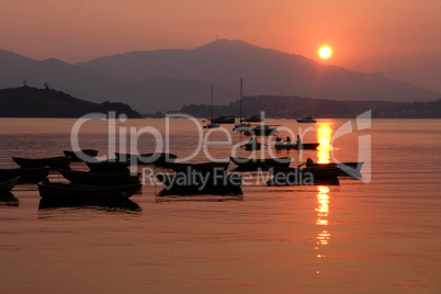 Silhouette of recreational boat, mountain with reflection at sun