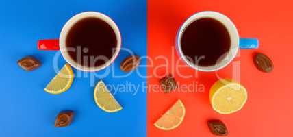 Red and blue cups with tea , lemon slices and chocolate candies