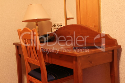 Schreibtisch und Stuhl in einem kleinen Hotelzimmer