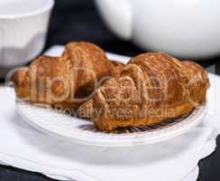 two baked croissants on a white plate