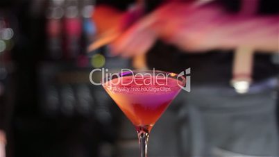 The barman prepares a set of cocktails on the bar counter.