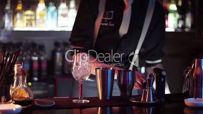 The barman prepares a set of cocktails on the bar counter.