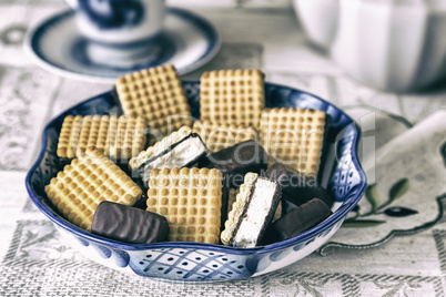 Cookies and chocolates in a ceramic vase.