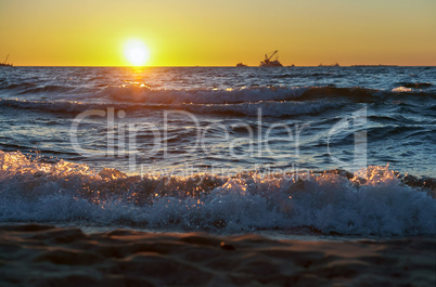 sunset on the sea, the waves beat against the breakwater, the sea at dawn, the ships on the horizon