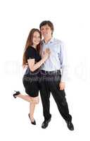 Happy young couple standing in dress and pants