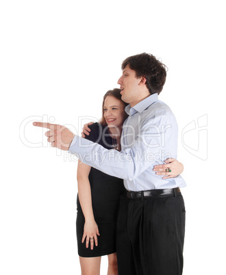 Young couple standing, man is pointing