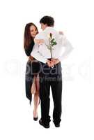 Man holding roses behind his back she is looking
