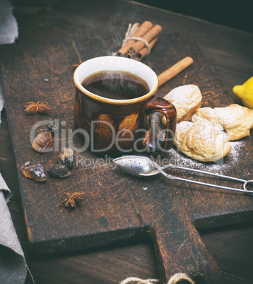 brown ceramic cup with black tea and croissants