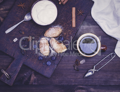 a cup of black tea, croissants and yogurt