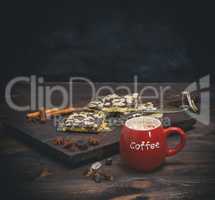 coffee with marshmallow in a red ceramic mug on a brown board an