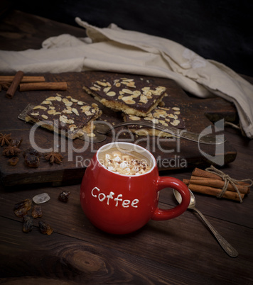 red ceramic cup with coffee and pieces of white marshmallow