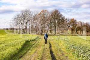 Woman is running on meadow path