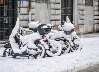 a group of snow-covered scooters