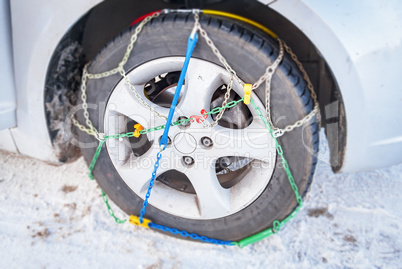 wheel of a car with mounted winter chains