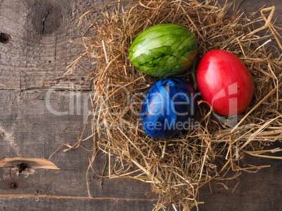 Three colored Easter eggs in a nest