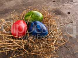 Three colored Easter eggs in a nest