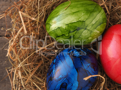 Three colored Easter eggs in a nest