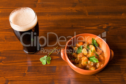 Traditional Irish Stew with a pint of stout beer and a shamrock