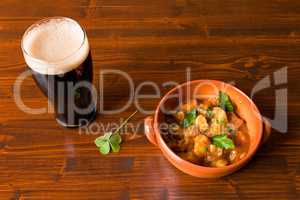 Traditional Irish Stew with a pint of stout beer and a shamrock