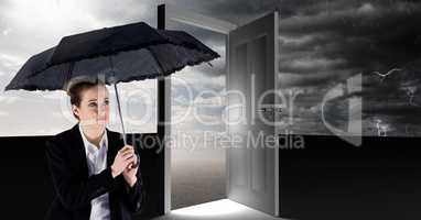 Woman holding umbrella and surreal open door with grey cloudy sky