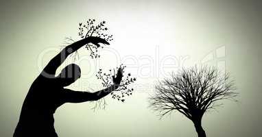 Person reaching with surreal tree branches silhouette