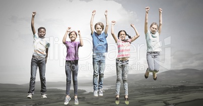 Children jumping for joy into sky with natural landscape