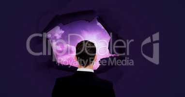Businessman looking through through surreal paper hole