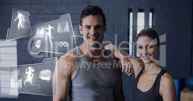 Athletic fit couple in gym with health interface