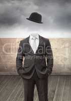 Headless man with surreal floating hat in front of wall