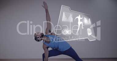 Athletic fit man exercising yoga with health interface