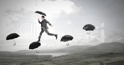 Man holding umbrella walking across umbrella's over nature landscape