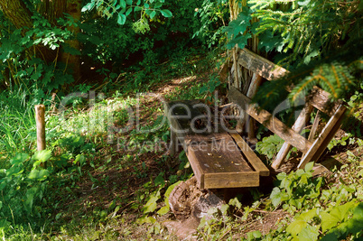 old Park bench by the water, broken wooden bench in the forest for tourists