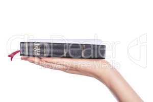 Woman hand holding the Holy Bible on white background