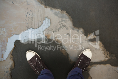 Composite image of man standing on hardwood floor