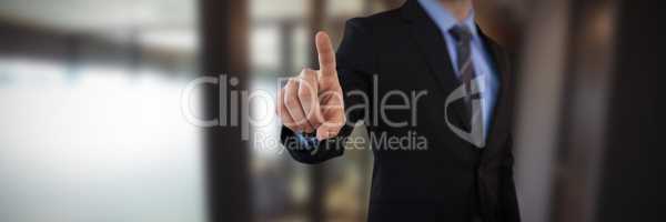 Composite image of mid section of businessman touching index finger on invisible screen