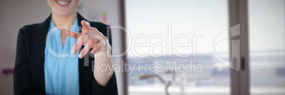 Composite image of mid section of smiling businesswoman pointing