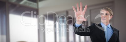 Composite image of smiling businessman gesturing on invisible interface