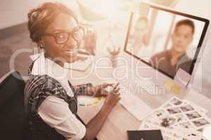 Composite image of woman working on computer while sitting at office