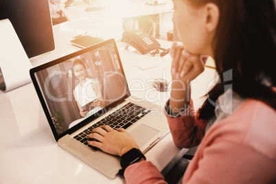 Composite image of woman working on laptop at office