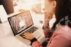 Composite image of woman working on laptop at office