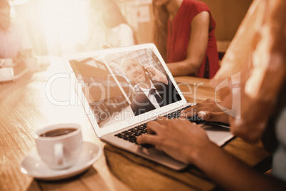 Composite image of businesswoman working on laptop at office