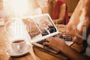 Composite image of businesswoman working on laptop at office