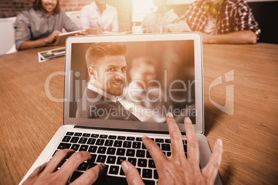 Composite image of cropped image of woman typing on laptop