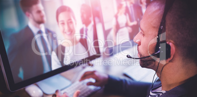 Composite image of man working on computer with headphone